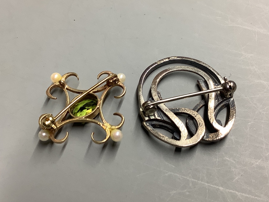 A modern 9ct gold, peridot and seed pearl set brooch, 27mm, gross 2.4 grams and a white metal brooch.